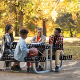 Family Sitting at Table in Park