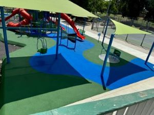 a playground surface with shade and play equipment