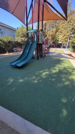 a playground slide with a shade