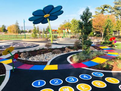 a play space with numbers on the ground and a flower shade element
