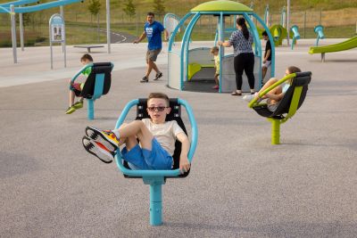 children in spinning seats with a larger spinner in the background