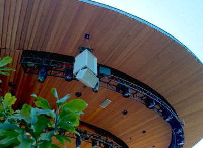 a speaker and lights hanging beneath a pavilion roof